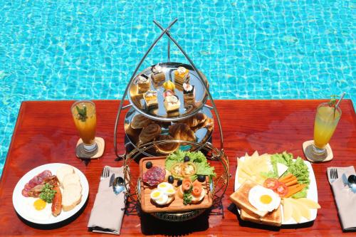 a table with a tray of food next to a pool at Hotel Del Luna Boutique in Da Nang
