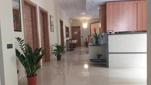 an office corridor with potted plants in a hallway at Hotel La Torre in Formigine