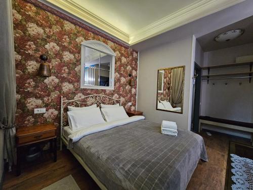 a bedroom with a bed with floral wallpaper at Studios on Grigore Vieru in Chişinău