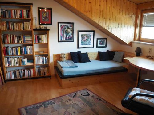 a living room with a couch and a book shelf at Haus Herberg Millstatt in Millstatt