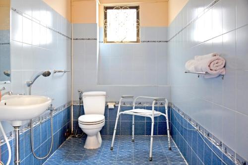 a blue bathroom with a toilet and a sink at Nhà Khách Làng May Mắn - Village Chance in Ho Chi Minh City