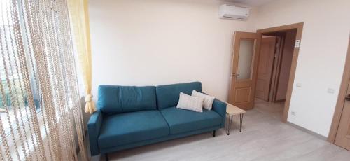 a living room with a blue couch and a table at FlatService Затишні та просторі апартаменти в ЖК Parklend in Kyiv