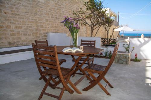 a wooden table with two chairs and a vase with flowers at MariMar in Bali