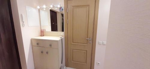 uma casa de banho com um lavatório e um espelho ao lado de uma porta em FlatService Затишні та просторі апартаменти в ЖК Parklend em Kiev