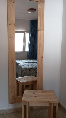 a bedroom with a bed and a mirror and a bench at Apartamentos Boomerang I in Tamaduste
