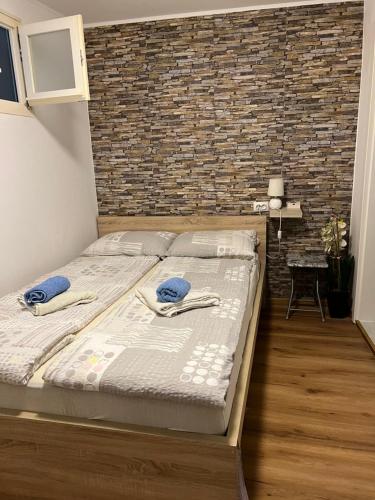 ein großes Bett in einem Zimmer mit Ziegelwand in der Unterkunft Studio Piran in Piran