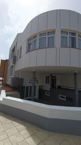 un gran edificio blanco con ventanas laterales en Apartamentos Boomerang II, en Tamaduste