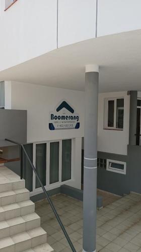 a building with a sign on the wall and stairs at Apartamentos Boomerang II in Tamaduste