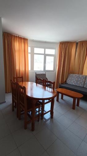 uma sala de estar com uma mesa e cadeiras e um sofá em Apartamentos Boomerang II em Tamaduste