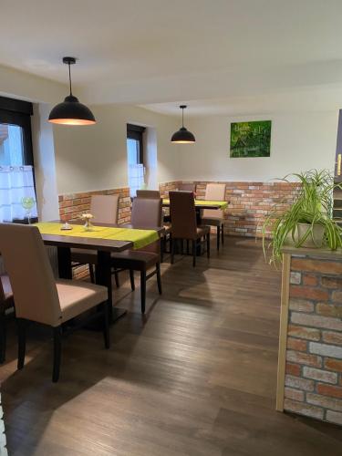 una sala da pranzo con tavoli, sedie e un muro di mattoni di Hotel Unter den Linden a Kierspe