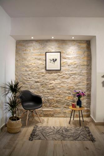 a chair and a table in a room with a stone wall at MariMar in Balíon
