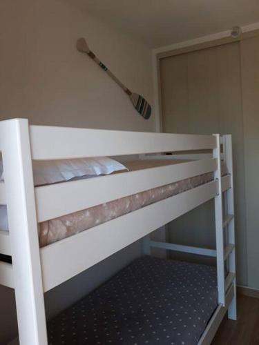 Ce lit superposé blanc se trouve dans un dortoir. dans l'établissement GITE LES BOTIAS, à Canet