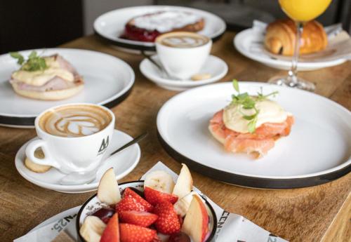 a table with plates of food and cups of coffee at Rooms25 in Amsterdam