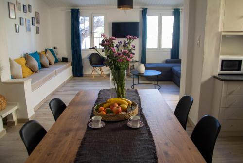 a table with a bowl of fruit and a vase of flowers at MariMar in Balíon