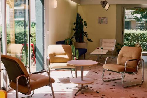 a waiting room with chairs and a table at Greet Hotel Versailles - Voisins Le Bretonneux in Voisins-le-Bretonneux