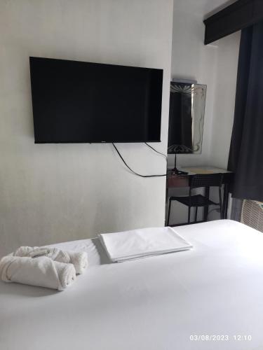 a bedroom with a bed with a flat screen tv on the wall at Citadel Inn in Manila