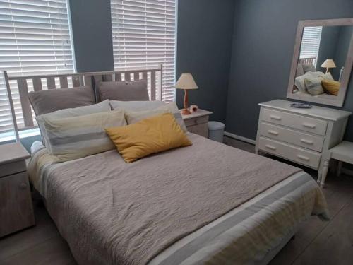 a bedroom with a bed with a mirror and a dresser at Corner Delight Full Back up power in Hermanus