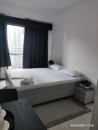 una camera da letto con un grande letto e una finestra di Citadel Inn a Manila