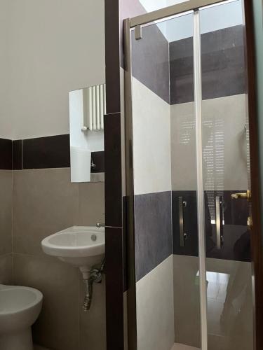 a bathroom with a shower with a sink and a toilet at Fellini Rimini in Rimini