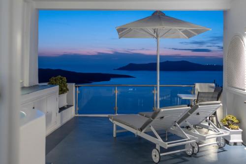 un balcone con tavolo, sedie e ombrellone di Asteras Villas a Firà