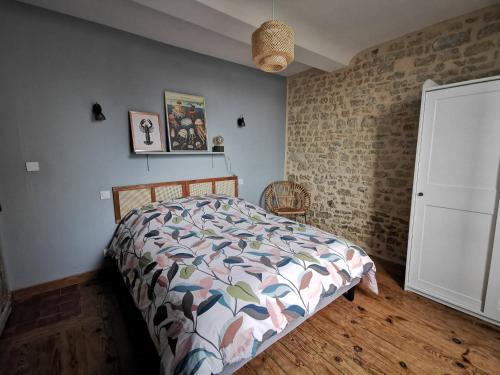 a bedroom with a bed and a brick wall at L'appart de Léo et Soso in Bayeux