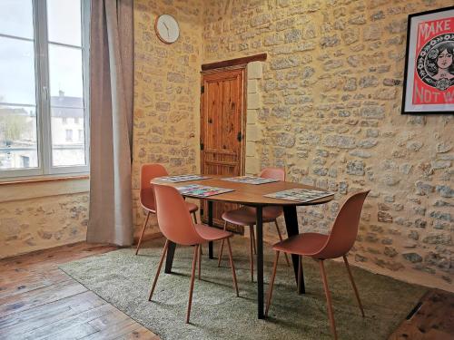 a dining room with a wooden table and chairs at L'appart de Léo et Soso in Bayeux