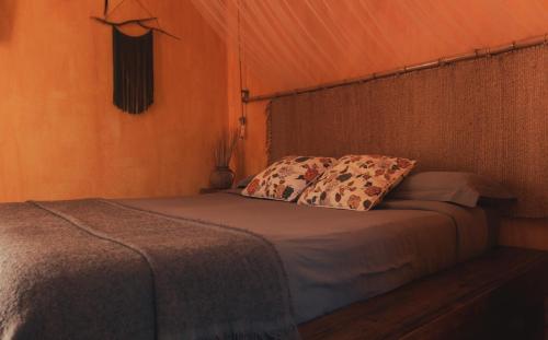 a bed in a tent with two pillows on it at Hostal Esfigueral in Es Figueral Beach