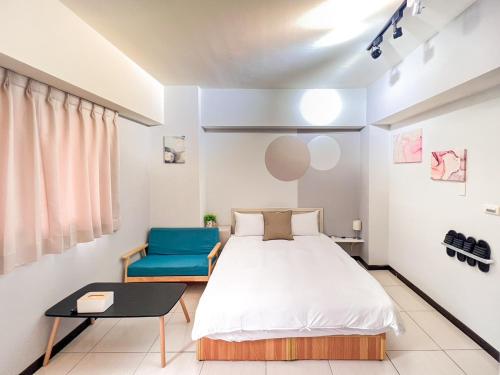 um quarto com uma cama e uma cadeira azul em 一中小窩馨 em Taichung