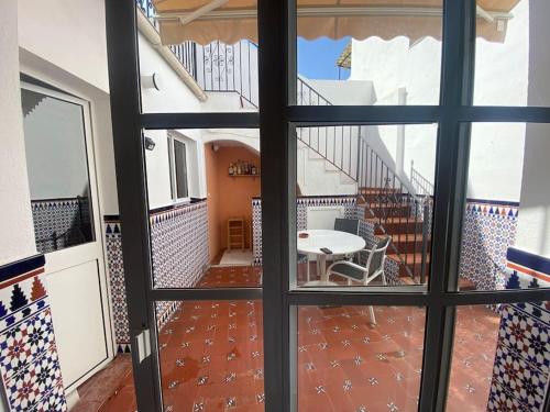 a view through a window of a room with a table and stairs at Casa Cumbres in Cumbres de San Bartolomé