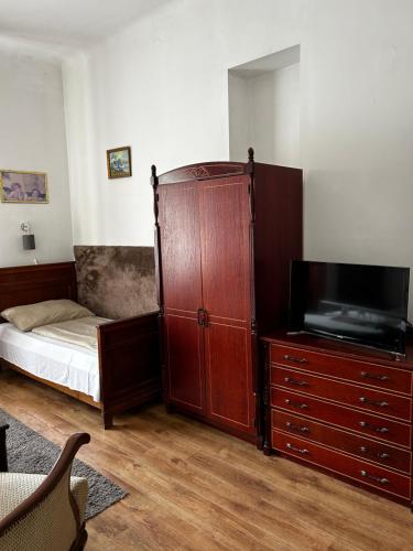 1 dormitorio con 1 cama y vestidor con TV en Kis Gellért Guesthouse, en Budapest