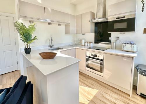 una cucina con armadi bianchi e piano di lavoro di Cliffords Reach at Bluebridge Court -City Centre - Free Parking a York