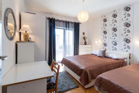 a hotel room with two beds and a window at Apartmani Jelena in Omiš