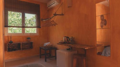 Habitación con una pequeña cocina con mesa y ventana. en Hostal Esfigueral, en Playa Es Figueral
