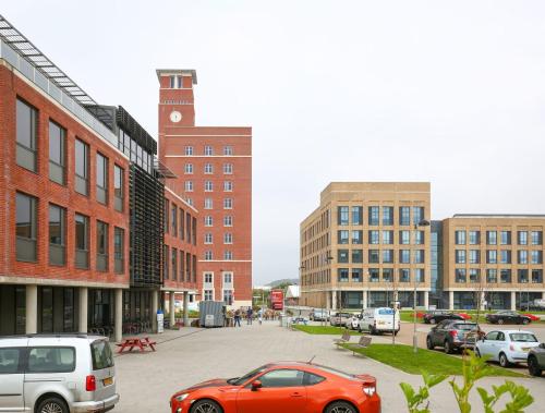a city street with cars parked in a parking lot at UPP Bay Campus Swansea in Swansea