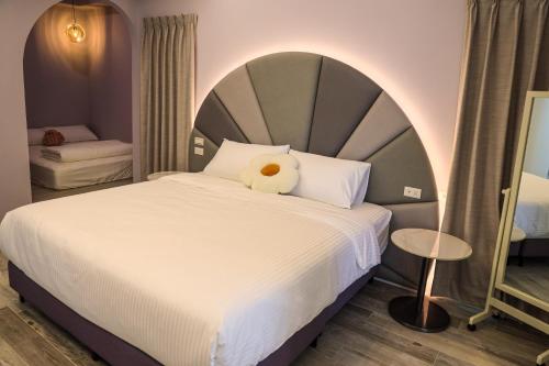 1 dormitorio con cama grande y almohada blanca en 鴝花甜點民宿 QuHua Sweety B&B, en Dongshan