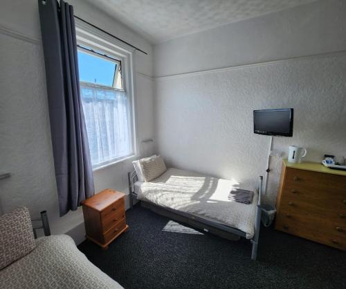 a small room with a bed and a window at The Moorfield in Blackpool