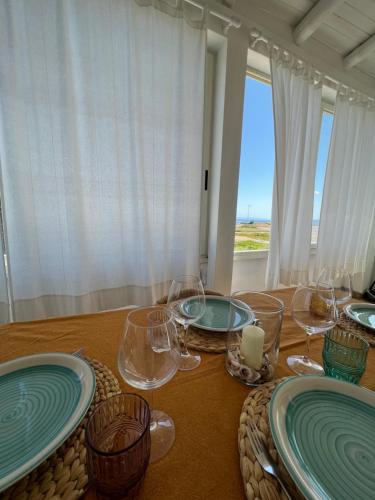 a table with plates and glasses on top of it at Da u Franchin in Carloforte