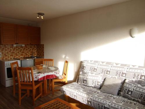 un salon avec une table et un canapé et une cuisine dans l'établissement Charmant studio alcôve Les Saisies - 4 pers, proche centre, balcon - FR-1-594-144, à Hauteluce