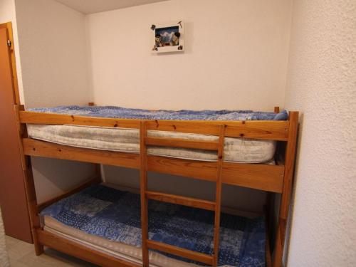 Ce lit superposé se trouve dans une petite chambre dotée de draps bleus. dans l'établissement Charmant studio alcôve Les Saisies - 4 pers, proche centre, balcon - FR-1-594-144, à Hauteluce