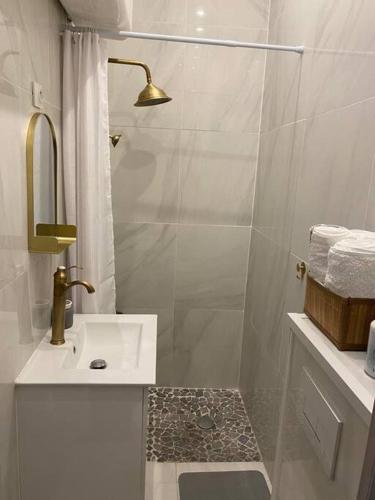 une salle de bain blanche avec une douche et un lavabo dans l'établissement Appartement tout confort, agréable à vivre, à Nice