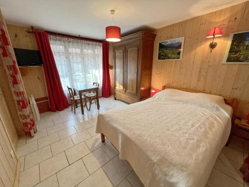 Un dormitorio con una cama y una mesa dentro. en Les Meublés du Rocher - Près du parc LE PAL, en Bourbon-Lancy