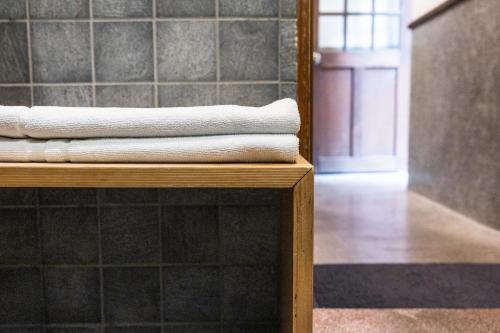 una pila de toallas sentadas en un estante en un baño en OrigInn Space en Taipéi