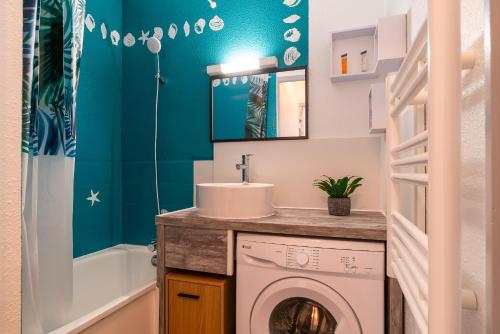 a bathroom with a washing machine and a sink at Ti Kréol - 5 minutes des plages in Saint-Nic