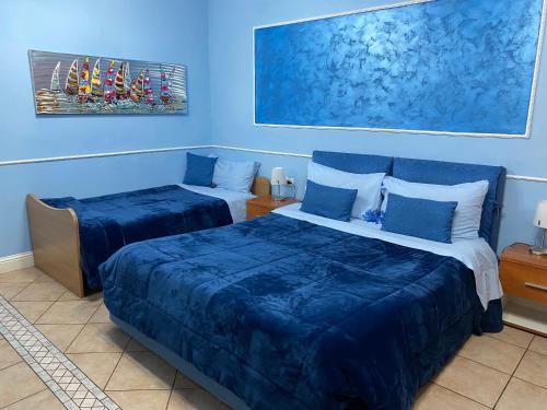 two beds in a room with blue walls at La Dea Hestia in Bosa