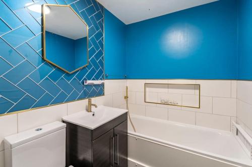 a bathroom with a tub and a sink and a mirror at Monalychee in London