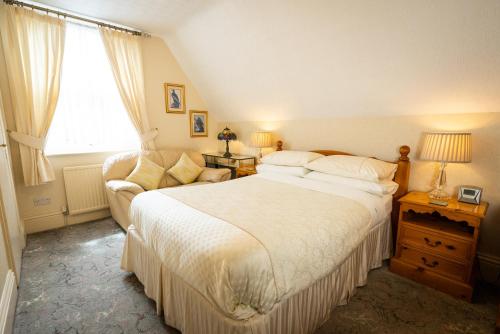 a bedroom with a large bed and a couch at Barbican House in York