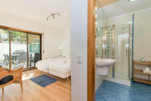 a bedroom with a bed and a bathroom with a sink at Poço do Bispo By ALGARTUR in Tavira