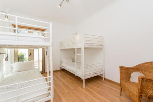 a bedroom with two bunk beds and a chair at Poço do Bispo By ALGARTUR in Tavira