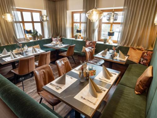 un restaurante con mesas, sillas y ventanas en La Pasta Hotel Restaurant, en Stumm