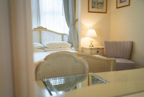 a bedroom with a bed and a chair and a window at Barbican House in York